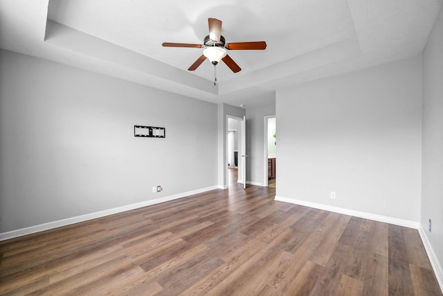 3051 Outfitters Dr, Clarksville, TN 37040 - empty room featuring a tray ceiling, wood finished floors, a ceiling fan, and baseboards