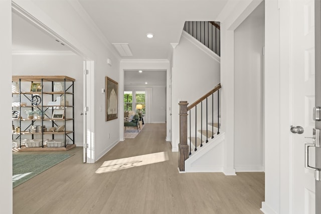 foyer featuring crown molding, stairs, wood finished floors, baseboards, and recessed lighting