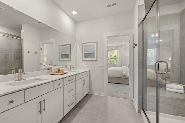 bathroom with double vanity, visible vents, connected bathroom, and a sink