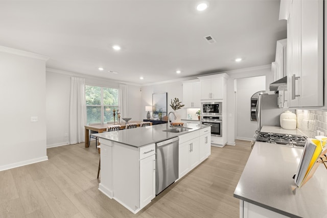 kitchen with a sink, light wood-type flooring, extractor fan, appliances with stainless steel finishes, and ornamental molding