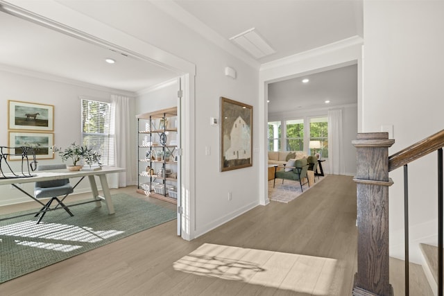 foyer entrance featuring baseboards, ornamental molding, wood finished floors, and plenty of natural light