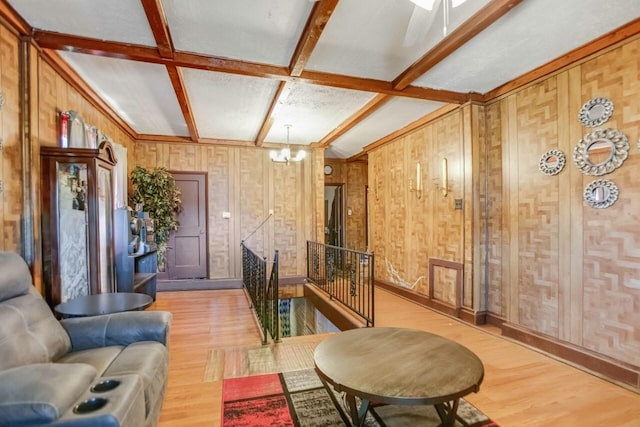 living area with coffered ceiling, beam ceiling, and wood finished floors