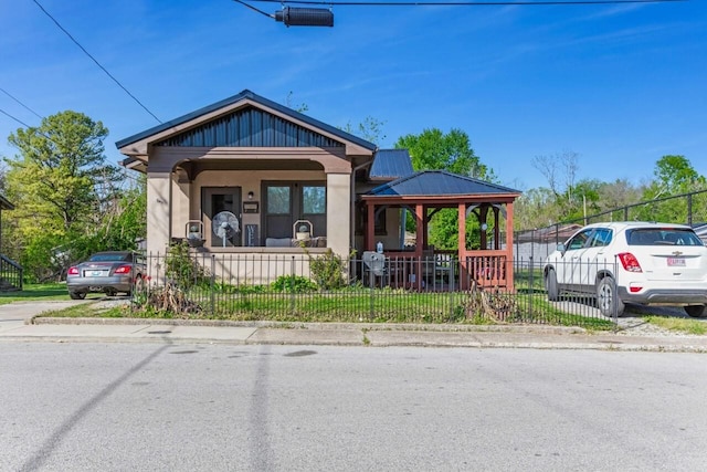bungalow-style house featuring a gazebo, metal roof, and a fenced front yard