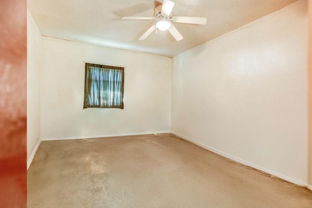 spare room with carpet floors, a ceiling fan, and baseboards