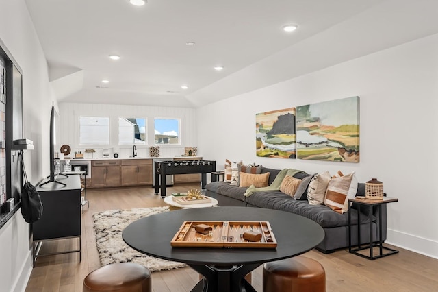 living area featuring baseboards, recessed lighting, and light wood-style floors