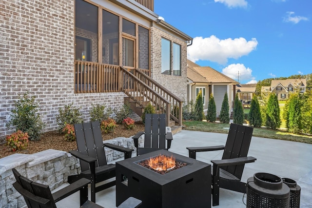 view of patio with a fire pit, a residential view, and stairway