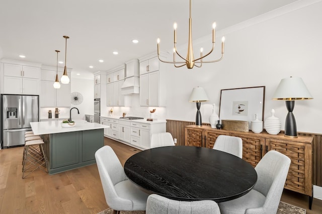 dining space with recessed lighting, light wood-style flooring, and a notable chandelier