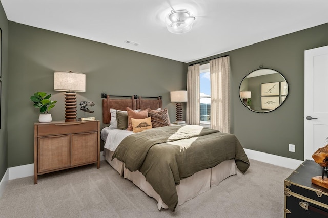bedroom featuring visible vents, baseboards, and light carpet