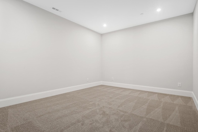 spare room with recessed lighting, baseboards, visible vents, and light carpet