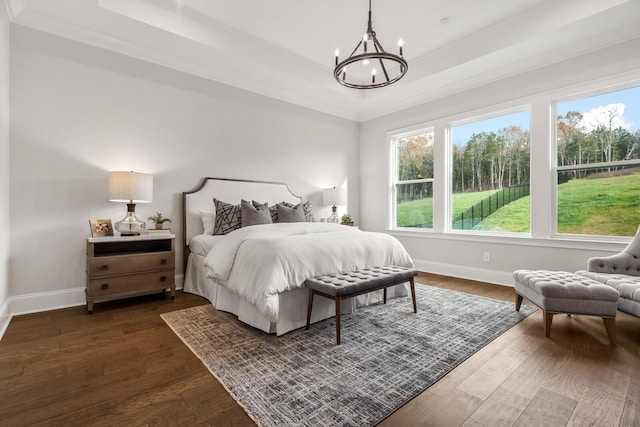 bedroom with baseboards, a tray ceiling, an inviting chandelier, and multiple windows