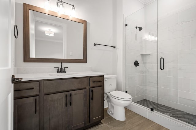 full bath with wood finished floors, vanity, a shower stall, and toilet