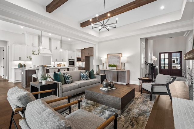 living area with an inviting chandelier, a towering ceiling, beamed ceiling, dark wood-style floors, and recessed lighting