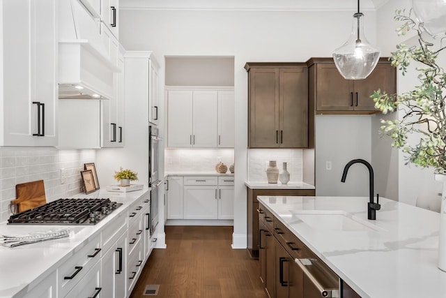 kitchen with white cabinets, a sink, dark wood-type flooring, and appliances with stainless steel finishes