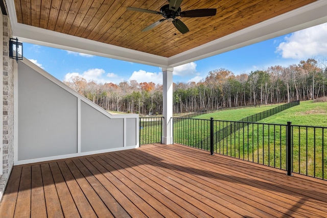 wooden terrace featuring a lawn and a ceiling fan