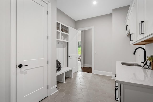 mudroom featuring baseboards, tile patterned floors, a sink, and recessed lighting