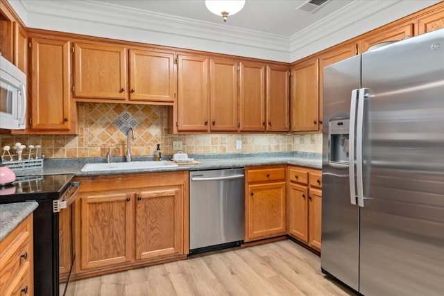 470 S Main St Unit 106, Ashland City, TN 37015 - kitchen featuring tasteful backsplash, a sink, brown cabinets, light wood-type flooring, and stainless steel appliances