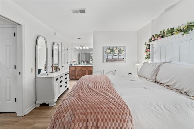 470 S Main St Unit 106, Ashland City, TN 37015 - bedroom with light wood finished floors, visible vents, baseboards, a chandelier, and ensuite bathroom
