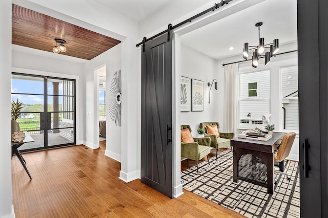 foyer featuring a barn door, light wood-style floors, cooling unit, baseboards, and wood ceiling