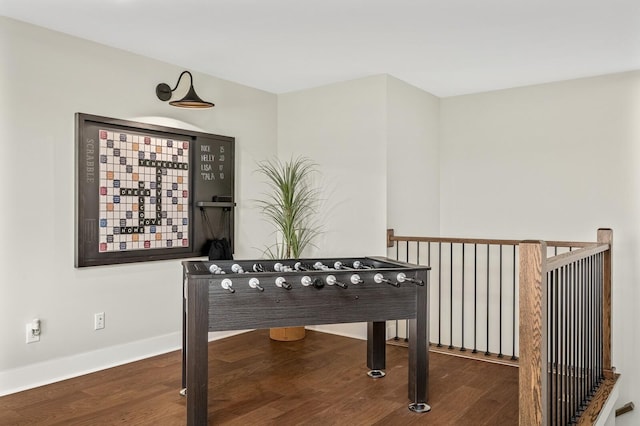 rec room with baseboards and wood finished floors