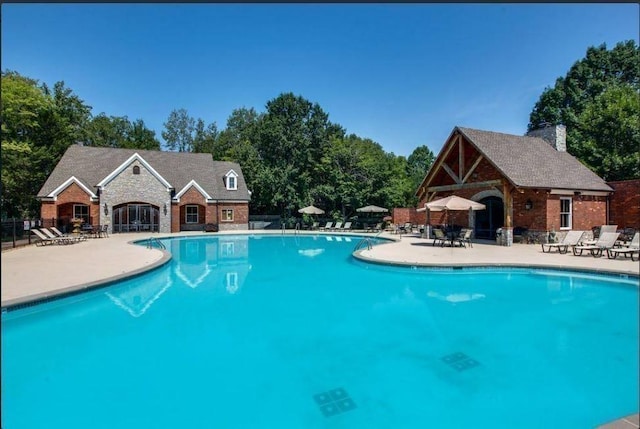 pool featuring fence and a patio