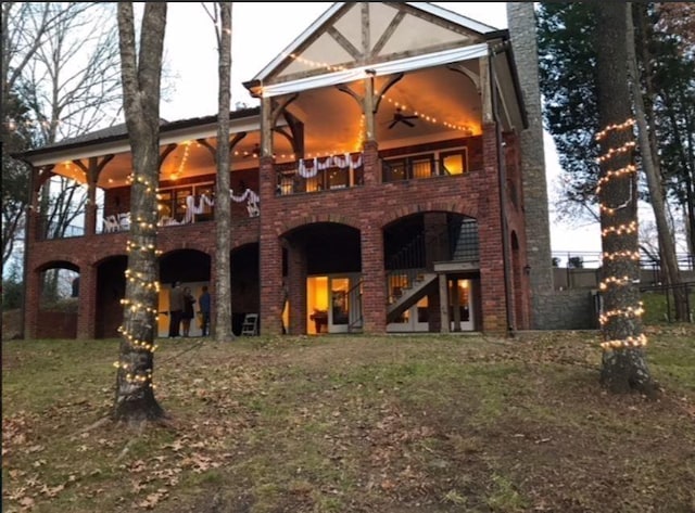 back of property with a chimney, brick siding, and stairs