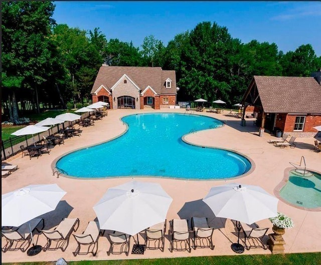 community pool featuring a patio and fence