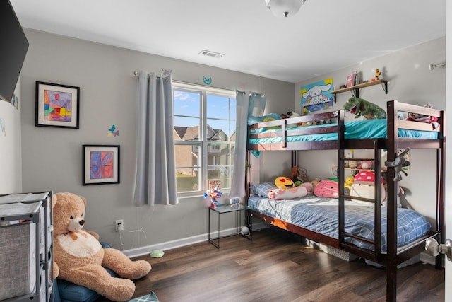 bedroom featuring wood finished floors, visible vents, and baseboards