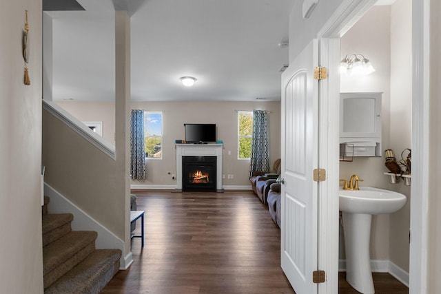 interior space with baseboards, wood finished floors, and a lit fireplace