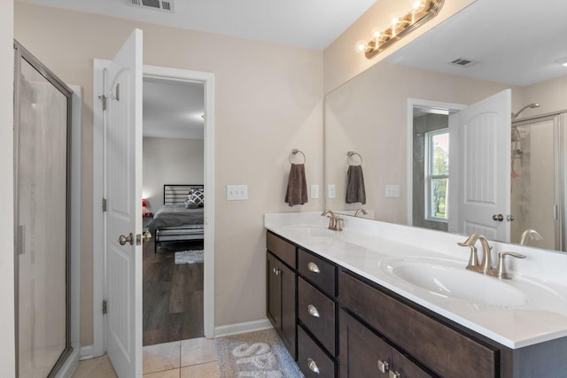bathroom with a shower stall, a sink, and visible vents