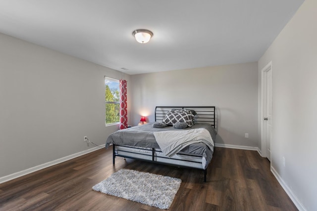 bedroom with baseboards and wood finished floors