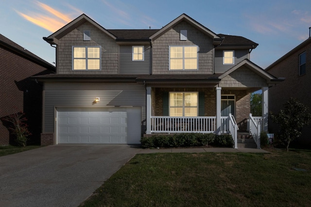 view of front facade with concrete driveway, a garage, a front yard, and covered porch