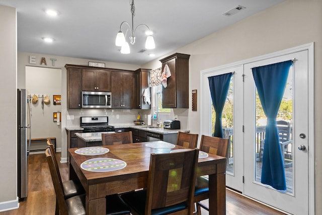 kitchen featuring dark wood finished floors, backsplash, visible vents, dark brown cabinetry, and appliances with stainless steel finishes
