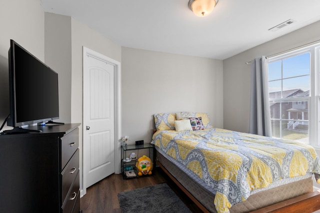 bedroom with visible vents and dark wood finished floors