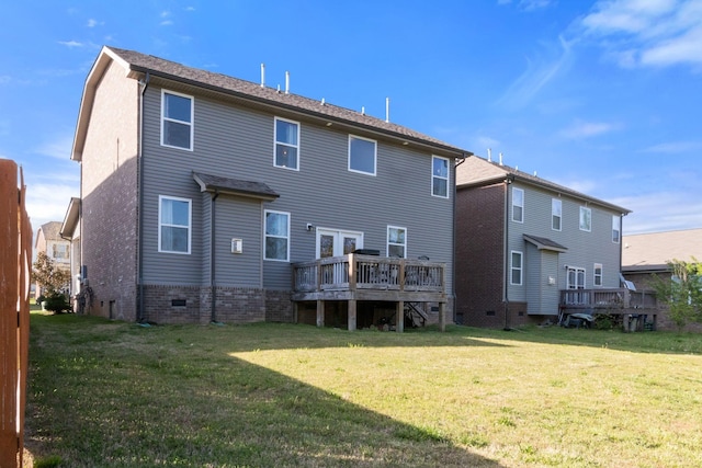 back of property with a lawn and a wooden deck