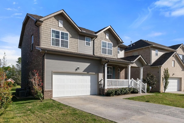 craftsman inspired home with a porch, concrete driveway, a front yard, and a garage