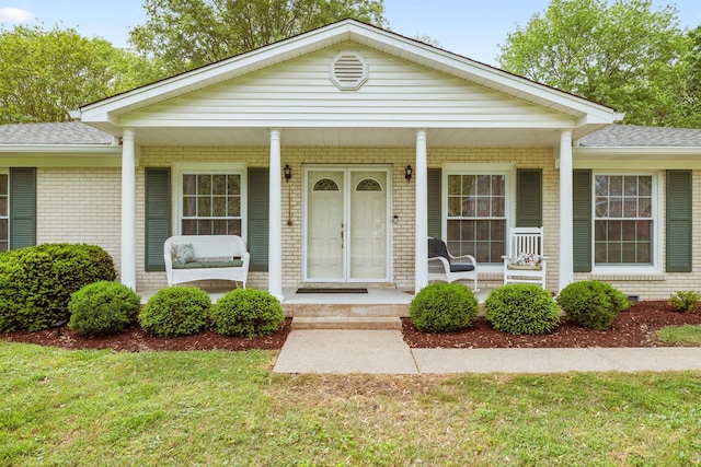 110 Ewingville Dr, Franklin, TN 37064 - view of front of home featuring covered porch, brick siding, roof with shingles, and a front lawn