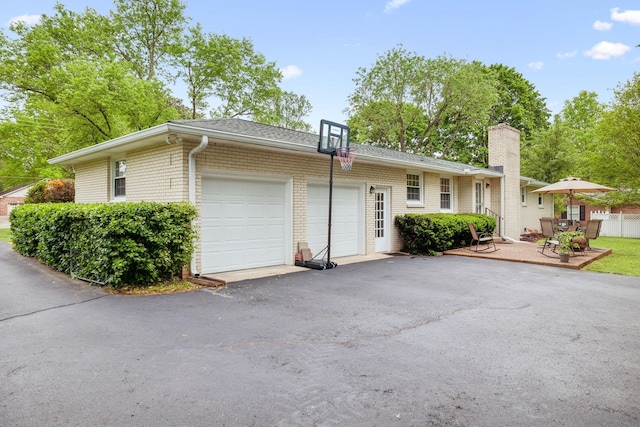 110 Ewingville Dr, Franklin, TN 37064 - view of front of house with a garage, driveway, a chimney, brick siding, and a shingled roof
