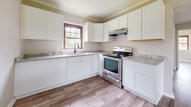 kitchen featuring a sink, electric range, light wood-style floors, under cabinet range hood, and ornamental molding