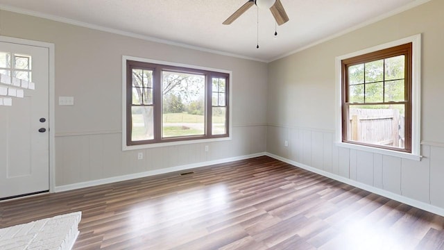 foyer featuring crown molding, plenty of natural light, a ceiling fan, and wood finished floors