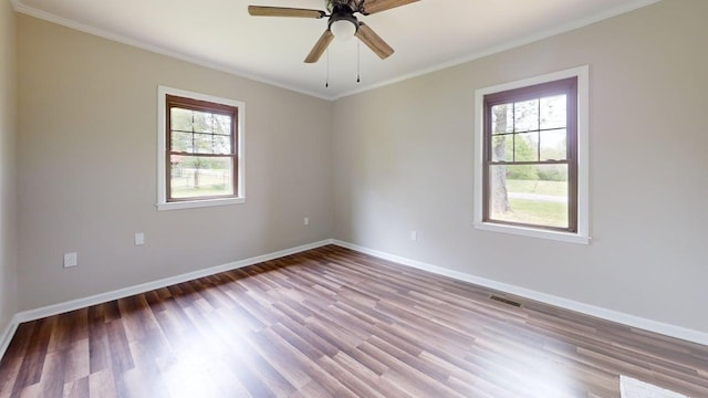 empty room featuring visible vents, baseboards, and wood finished floors