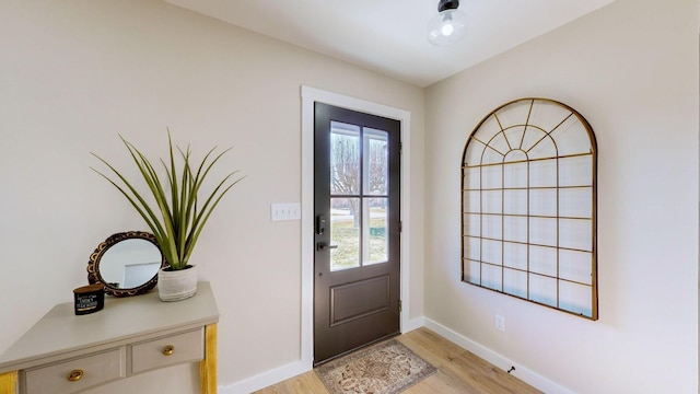 foyer with light wood-style flooring and baseboards