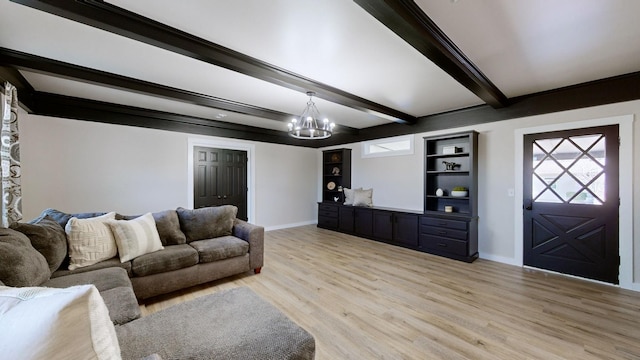living area featuring beamed ceiling, light wood-style flooring, baseboards, and an inviting chandelier