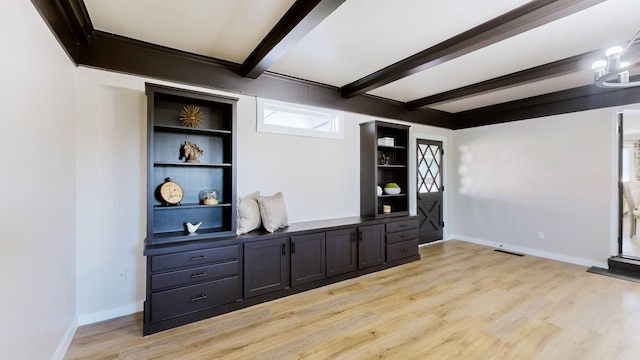 unfurnished living room with beamed ceiling, light wood-style floors, and baseboards