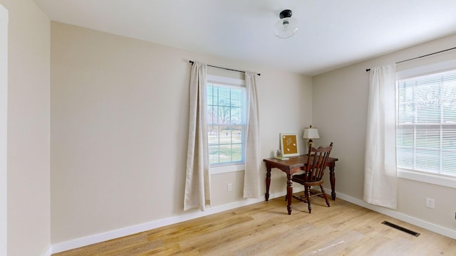 office with baseboards, visible vents, and light wood-style flooring