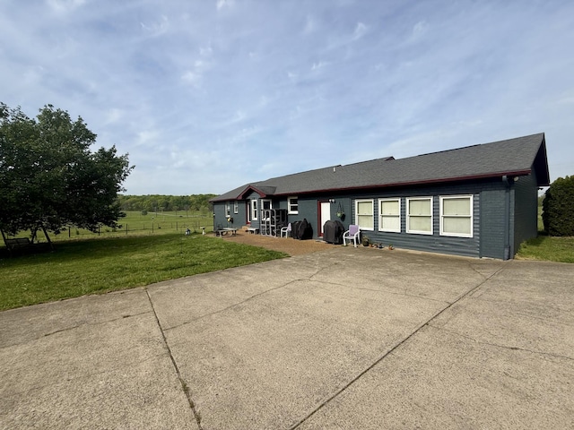 view of front of home with fence, a patio, and a front yard