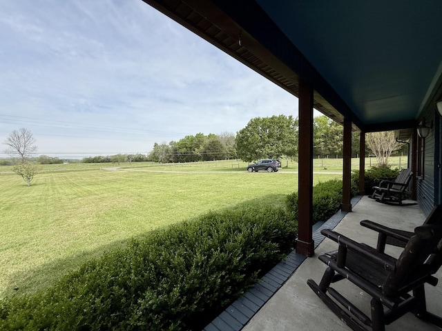 view of yard with a rural view and covered porch