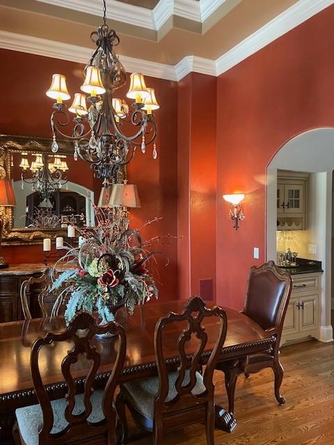 889 Plantation Blvd, Gallatin, TN 37066 - dining space with ornamental molding, arched walkways, a notable chandelier, and wood finished floors