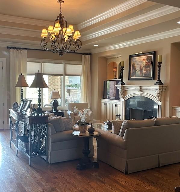 889 Plantation Blvd, Gallatin, TN 37066 - living area featuring a fireplace, wood finished floors, an inviting chandelier, and crown molding
