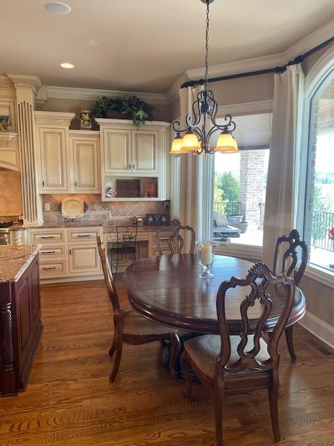 889 Plantation Blvd, Gallatin, TN 37066 - dining area with baseboards, dark wood-style floors, an inviting chandelier, and ornamental molding