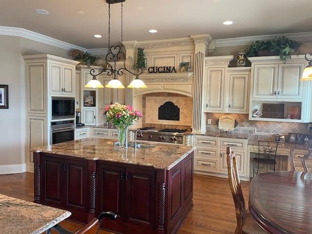 889 Plantation Blvd, Gallatin, TN 37066 - kitchen featuring light stone counters, a sink, pendant lighting, appliances with stainless steel finishes, and dark wood-style floors